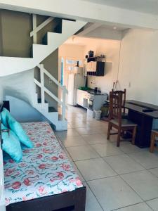 a living room with a bed and a kitchen at Pousada Portal da Praia in Capão da Canoa
