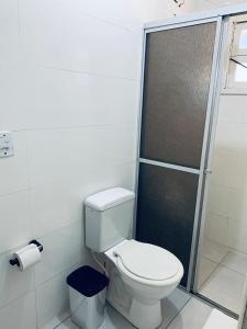 a bathroom with a toilet and a shower at Pousada Portal da Praia in Capão da Canoa