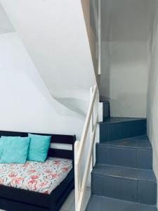 1 cama con almohadas azules junto a una escalera en Pousada Portal da Praia en Capão da Canoa