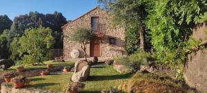 a stone house in a garden with potted plants at Quinta da Costeira in Sever do Vouga