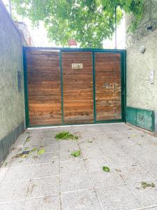 una gran puerta de madera en un garaje en el lateral de un edificio en Bohemio dpto a metros del Parque General San martín en Godoy Cruz