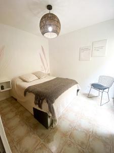 1 dormitorio con 1 cama, 1 silla y 1 lámpara en Bohemio dpto a metros del Parque General San martín en Godoy Cruz