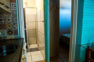 a bathroom with a shower and a glass door at Residencial Solar Três in Imbé