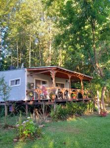 a tiny house with a porch and a deck at Cabaña de las mariposas in Tigre