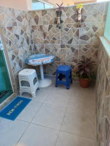 une chambre avec deux tabourets, une table et un banc dans l'établissement kitnet da Gi casa completa 30 metros do mar de Arraial do Cabo, à Arraial do Cabo