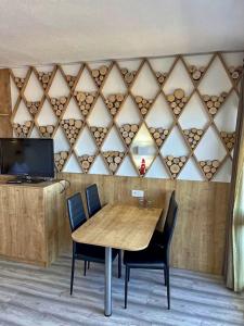 Apartmány Almberg في فيليبسغويت: غرفة طعام مع طاولة وكراسي خشبية
