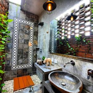 La salle de bains est pourvue d'un lavabo et d'un miroir. dans l'établissement Oma Watu Inn, à Pringkuku