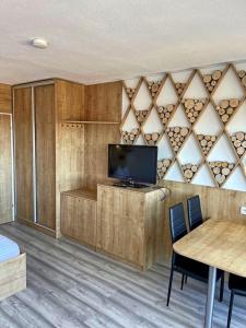 een kamer met een tv en een tafel met stoelen bij Apartmány Almberg in Philippsreut