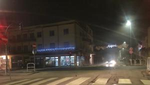 una calle de ciudad vacía por la noche con un edificio en SMM Apartment, en Ferrara