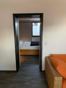 een kamer met een spiegel, een bed en een bank bij ALB-APARTMENT-WESTERHEIM Kurort in Westerheim