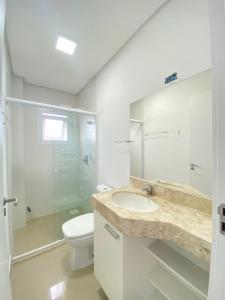 y baño con lavabo, aseo y ducha. en Apartamento com vista para o mar en Capão da Canoa