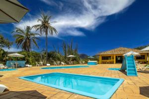 einen Pool in einem Resort mit Palmen in der Unterkunft Hotel Fazenda Minas Real in Simão Pereira