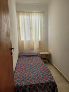 ein kleines Schlafzimmer mit einem Bett und einem Fenster in der Unterkunft Apartamento Alem in Gualeguaychú