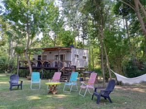 a group of chairs and tables in front of a trailer at Cabaña de las mariposas in Tigre
