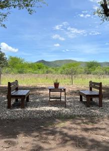 tres bancos de parque y una mesa con una maceta en Casa Azul en Santa Rosa de Calamuchita