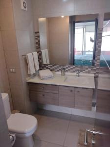 a bathroom with a sink and a toilet and a mirror at 2 Poniente con 3 Norte HERMOSOS Departamentos in Viña del Mar