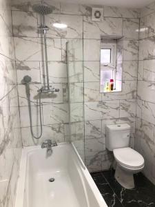 a bathroom with a tub and a toilet and a sink at Lovely 3 Bedroom Entire Home With Street Parking - Close to NEC, BHX Airport - Sleeps 6 Guests IDEAL FOR CONTRACTORS & FAMILIES in Birmingham