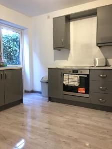 an empty kitchen with a stove and a window at Lovely 3 Bedroom Entire Home With Street Parking - Close to NEC, BHX Airport - Sleeps 6 Guests IDEAL FOR CONTRACTORS & FAMILIES in Birmingham