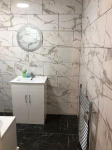 a bathroom with a white sink and a white counter at Lovely 3 Bedroom Entire Home With Street Parking - Close to NEC, BHX Airport - Sleeps 6 Guests IDEAL FOR CONTRACTORS & FAMILIES in Birmingham
