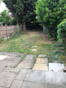 a backyard with a fence and a yard withgrass at Lovely 3 Bedroom Entire Home With Street Parking - Close to NEC, BHX Airport - Sleeps 6 Guests IDEAL FOR CONTRACTORS & FAMILIES in Birmingham