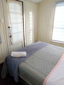 - une chambre avec un lit et une serviette dans l'établissement Cabañas Don Peto, à Ancud