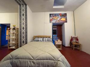- une chambre avec un lit et une télévision murale dans l'établissement The Sleepy Mouse, à Cusco