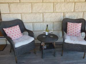 2 chaises et une table avec 2 verres de vin dans l'établissement Grey Goose @ Smiths, à Smiths Beach