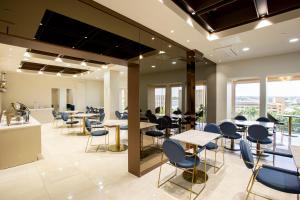 a cafeteria with tables and chairs and windows at The Bayview Hotel Guam in Tumon