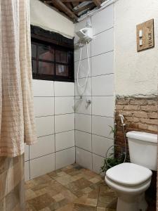 a bathroom with a toilet and a shower at Casinha do Morro - Centro Histórico in Goiás