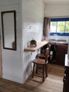 a kitchen with a table and a chair and a mirror at Bangalô dos Araçás - sítio Vô Haack in Gramado