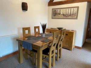 a dining room table with chairs and a wooden tableablish at Stable Cottage, Old Mill Farm, Cotswold Water Park in Cirencester