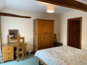 - une chambre avec un lit, une commode et un miroir dans l'établissement Stable Cottage, Old Mill Farm, Cotswold Water Park, à Cirencester