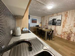 a kitchen with a sink and a table with a cow on the wall at 894 Holly Court in Coober Pedy