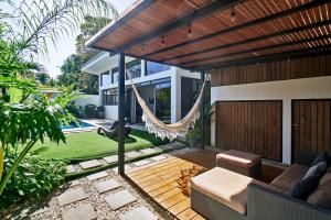 a patio with a hammock and a house at Villa Koi ~ Brand NEW Villa ~ 2 Bedrooms with Pool in Carmen