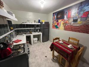 a kitchen with a stove and a table in it at The Sleepy Mouse in Cusco