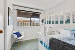 a bedroom with two bunk beds and a chair at Beachside Serenity - a quiet beachside hideaway in Mount Martha