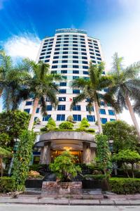 a building with palm trees in front of it at Muong Thanh Grand Hanoi Hotel in Hanoi