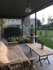 patio con banco, mesa y TV en Casa grande barrio Rumenco en Mar del Plata