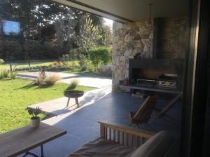 a patio with a stone fireplace and a bench at Casa grande barrio Rumenco in Mar del Plata