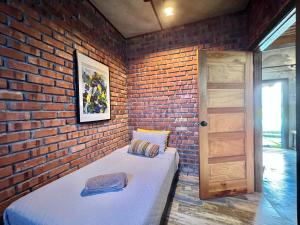 a brick walled room with a bed and a door at Classic Traditional Villa with Breathtaking View Pool WIFI in Pantai Cenang