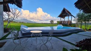 a patio with a table and chairs next to a pool at Classic Traditional Villa with Breathtaking View Pool WIFI in Pantai Cenang