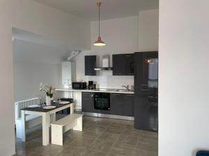 a kitchen with black and white cabinets and a table at Appart cocoon, résidence A.T.F in Aulnay-sous-Bois