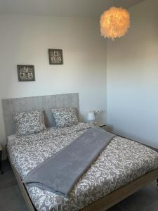 a large bed in a bedroom with a chandelier at Appart cocoon, résidence A.T.F in Aulnay-sous-Bois +8 photos