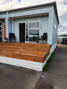 a house with a deck with two chairs on it at Opotiki Waiotahi Beach Retreat in Opotiki