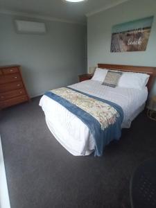 a bedroom with a large bed with white sheets at Opotiki Waiotahi Beach Retreat in Opotiki