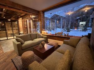 a living room with couches and a large window at Everest Hotel in Val dʼIsère