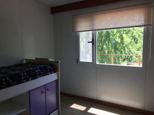 um quarto com uma janela e uma mesa com uma cortina de janela em Casa en el Delta de Tigre em Tigre
