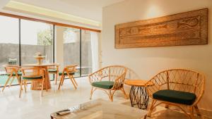 a dining room with wooden chairs and a table and a table and chairsktop at Annora Villas Seminyak in Seminyak