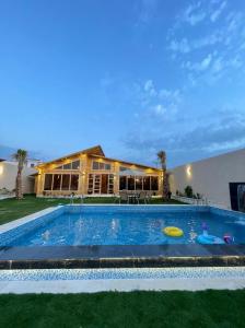 a swimming pool with a house in the background at شاليهات ريموندا الريفيه الطائف in Taif