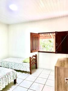 sypialnia z 2 łóżkami i oknem w obiekcie Casa do Pôr do Sol w mieście Triunfo